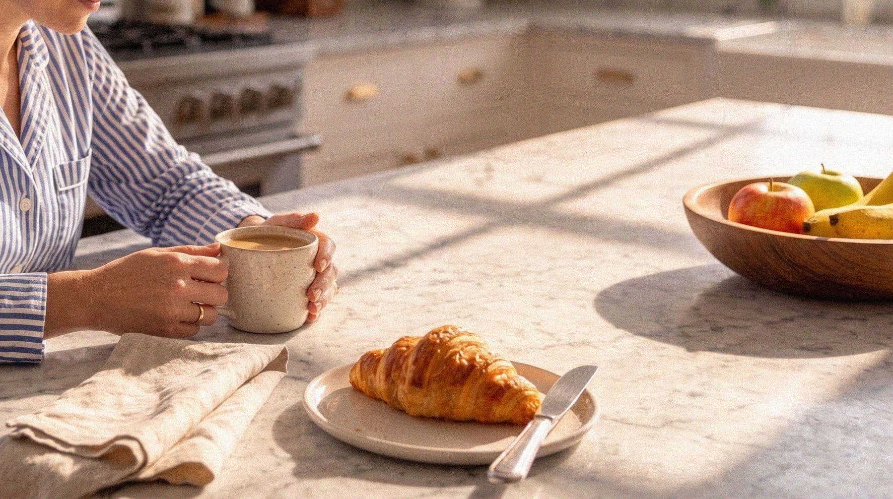 Hands around a coffee cup at the kitchen counter, early light